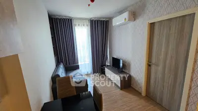 Modern living room with stylish decor, featuring a cozy sofa, flat-screen TV, and elegant curtains.