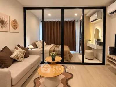 Modern apartment interior with cozy living room and stylish bedroom separated by glass partition.