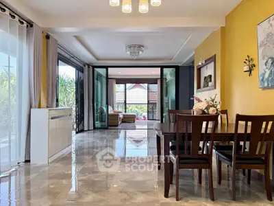 Spacious living room with elegant dining area and garden view, featuring modern decor and ample natural light.