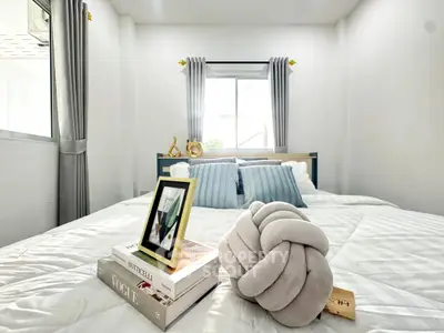 Cozy bedroom with stylish decor and natural light, perfect for relaxation and comfort.