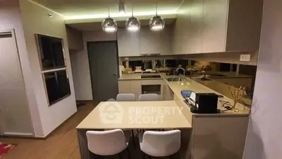 Modern kitchen with sleek cabinetry and dining area in contemporary apartment