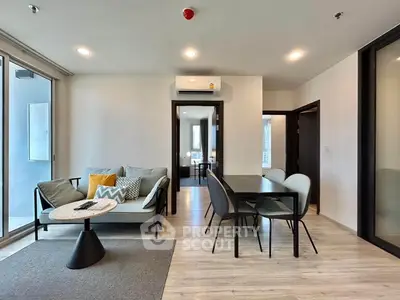 Modern living room with sleek furniture and dining area in open layout apartment.