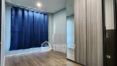 Spacious bedroom with wooden flooring and large mirrored wardrobe