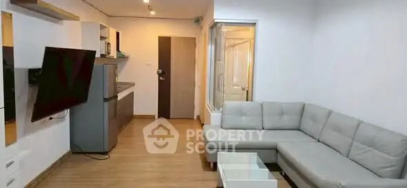 Modern living room with sleek furniture and open kitchen layout in a stylish apartment.