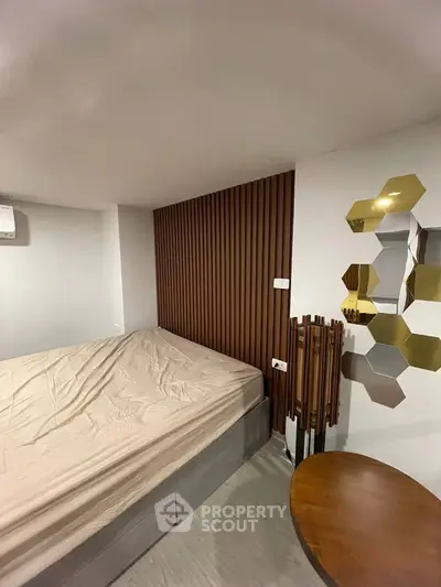 Modern bedroom with stylish wood paneling and unique hexagonal mirror design.