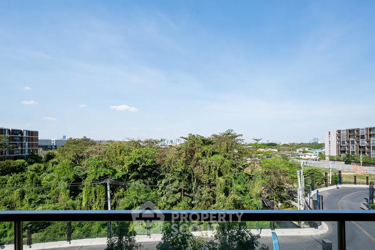 Stunning balcony view overlooking lush greenery and cityscape, perfect for relaxation.