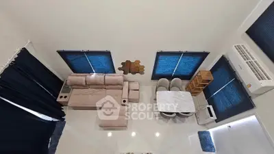 Modern living room with sleek furniture and large windows, featuring a cozy sofa and elegant dining area.
