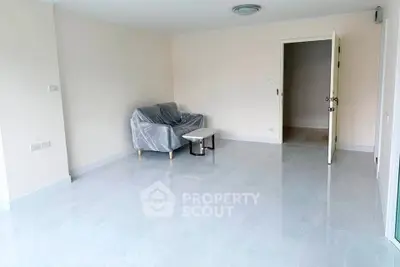 Spacious living room with minimalistic decor and tiled flooring