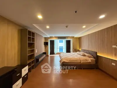 Spacious bedroom with modern wooden decor and ample natural light