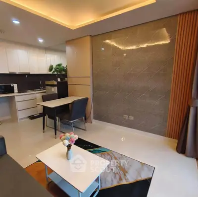 Modern living room with open kitchen, stylish decor, and elegant lighting in a contemporary apartment.