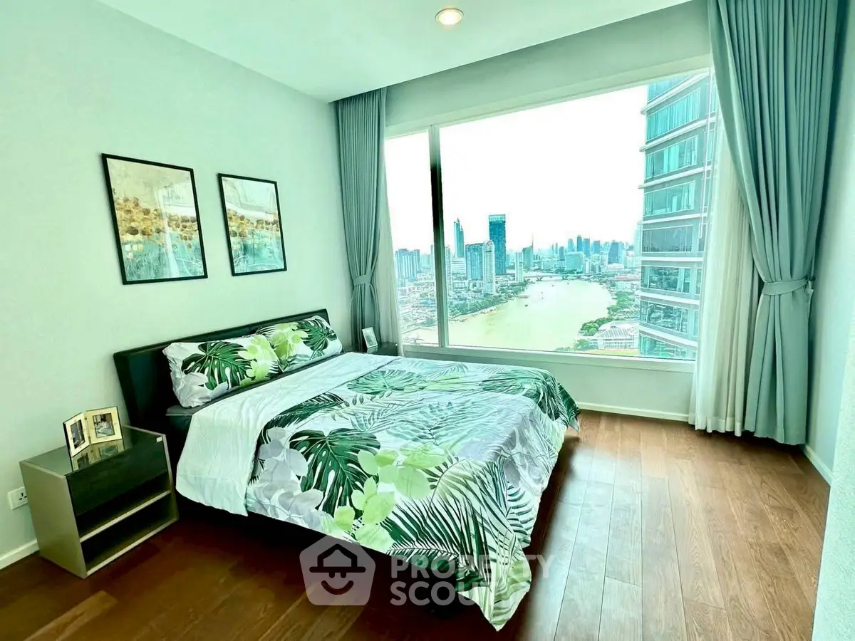 Luxurious bedroom with stunning city and river view, featuring modern decor and large window.
