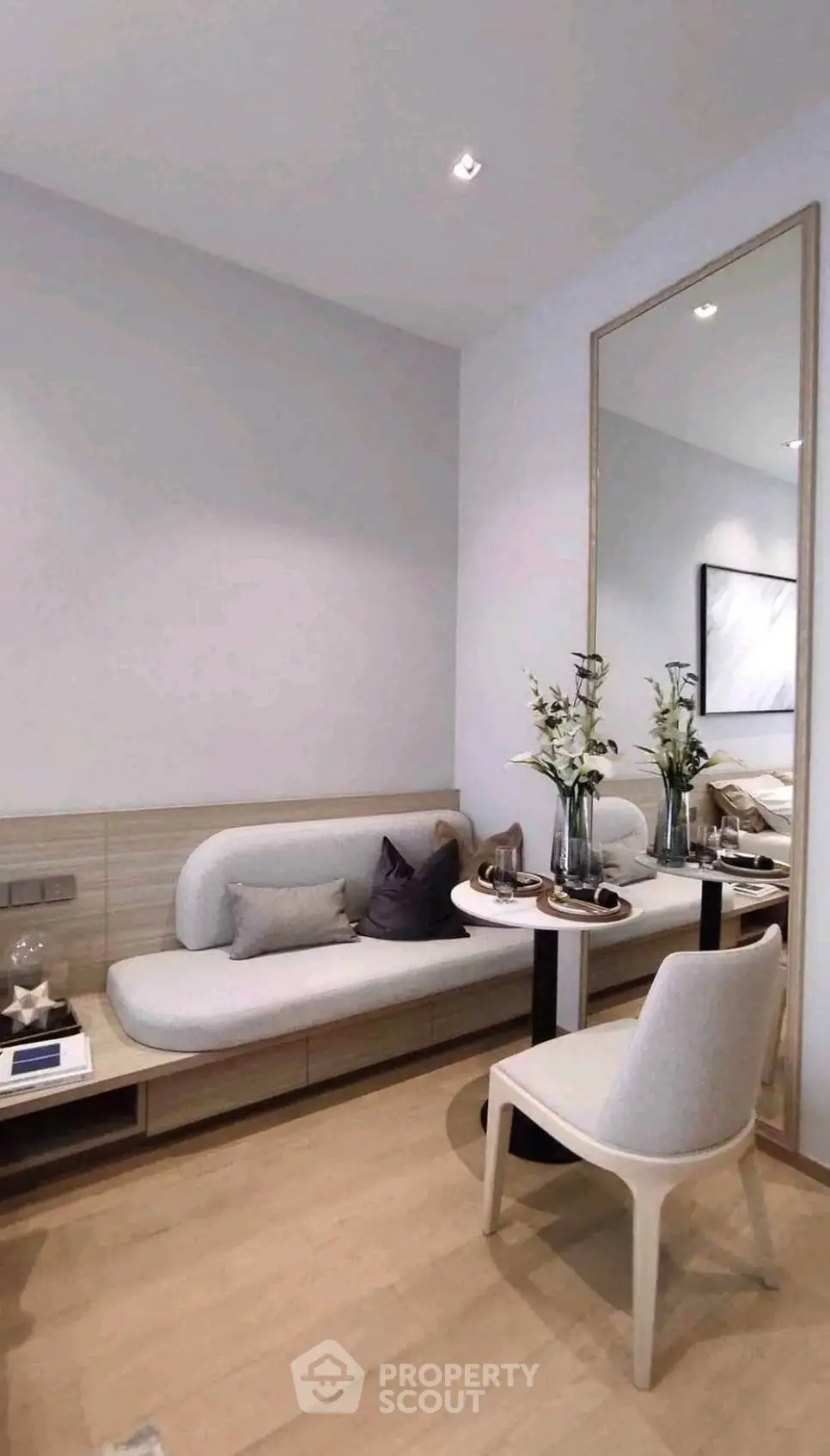 Modern living room with stylish furniture and large mirror enhancing space