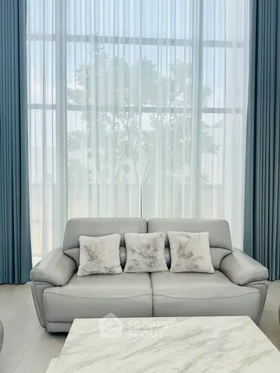 Elegant living room with plush sofa and floor-to-ceiling windows