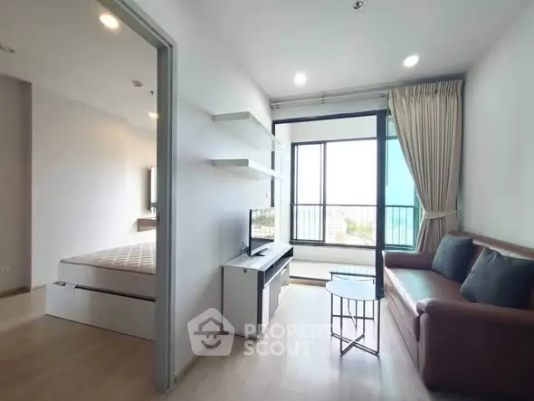Modern apartment with cozy living room and bedroom, featuring large windows and stylish furnishings.