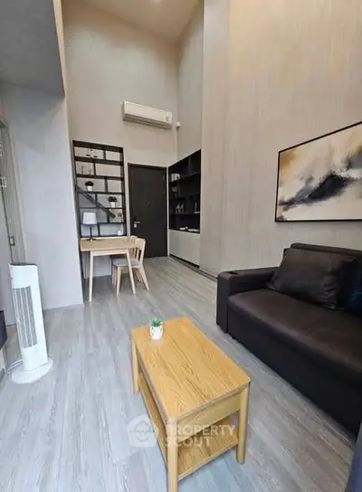 Modern living room with high ceiling, stylish furniture, and elegant decor in a contemporary apartment.