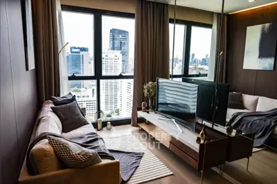 Modern living room with city view, featuring sleek furniture and large windows.