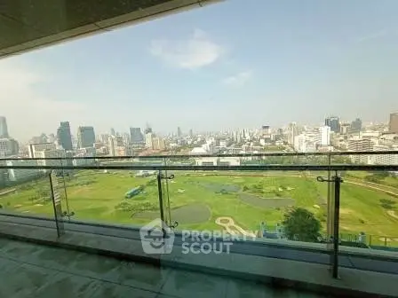 Stunning cityscape view from a high-rise balcony overlooking a lush golf course.