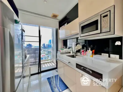 Modern kitchen with sleek appliances and city view from balcony