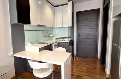 Modern compact kitchen with sleek cabinetry and integrated appliances in a stylish apartment.