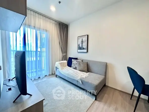 Modern living room with cozy sofa and stylish decor, featuring natural light and elegant furnishings.