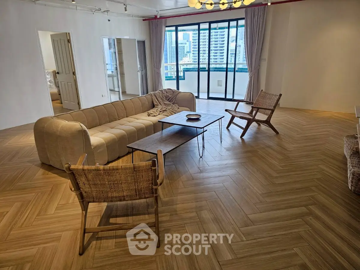 Spacious modern living room with elegant parquet flooring and city view balcony.