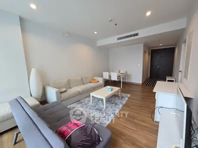 Spacious modern living room with stylish furniture and wooden flooring in a contemporary apartment.