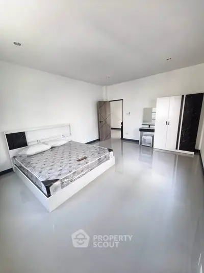 Spacious minimalist bedroom with sleek flooring and modern furniture