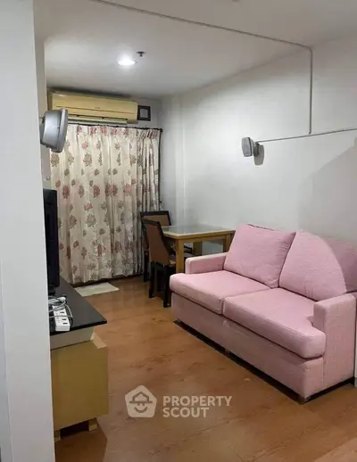 Cozy living room with pink sofa and dining area in modern apartment