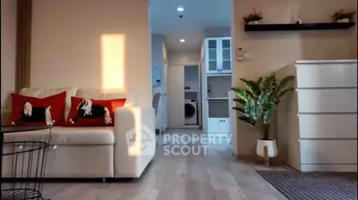 Modern living room with stylish decor and natural light, featuring a cozy sofa and elegant flooring.