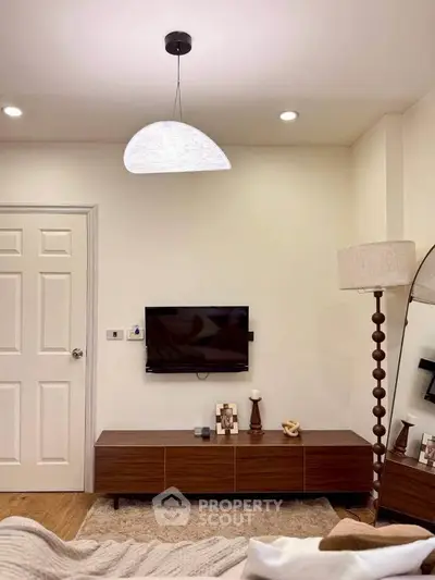 Stylish living room with modern decor and cozy ambiance, featuring sleek furniture and elegant lighting.