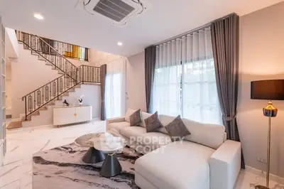 Luxurious modern living room with elegant staircase and stylish decor