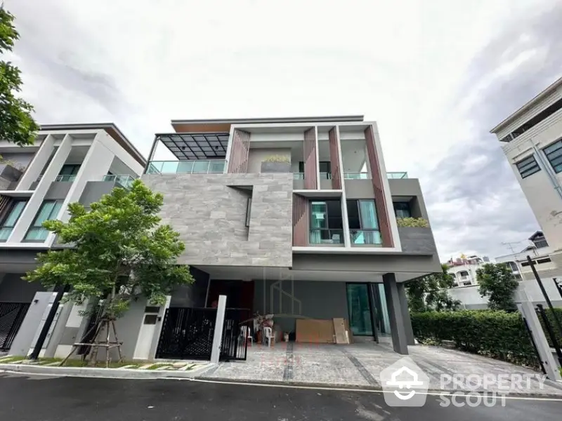 Modern multi-story residential building with sleek design, large windows, and a spacious garage, set in a tranquil neighborhood.