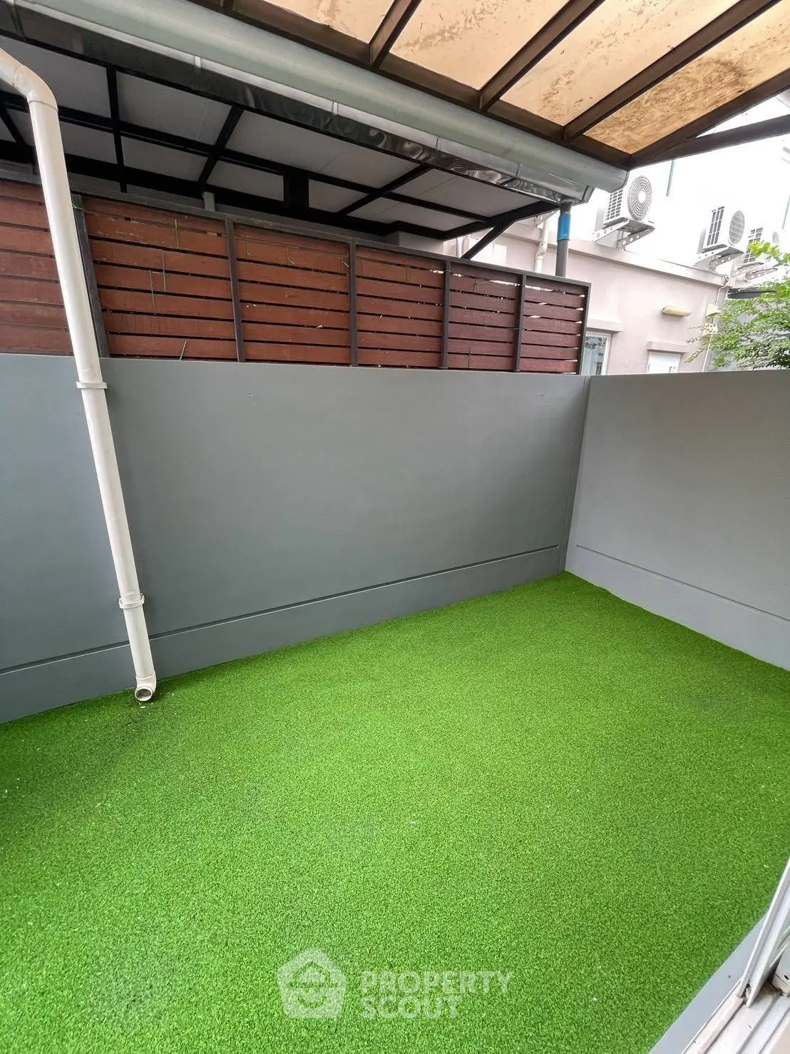 Charming outdoor space with artificial grass and privacy fence, perfect for relaxation or small gatherings.
