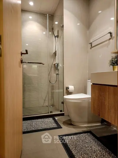 Modern bathroom with glass shower and sleek fixtures in a contemporary apartment.