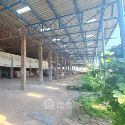 Spacious industrial warehouse with high ceilings and open layout, ideal for storage or manufacturing.