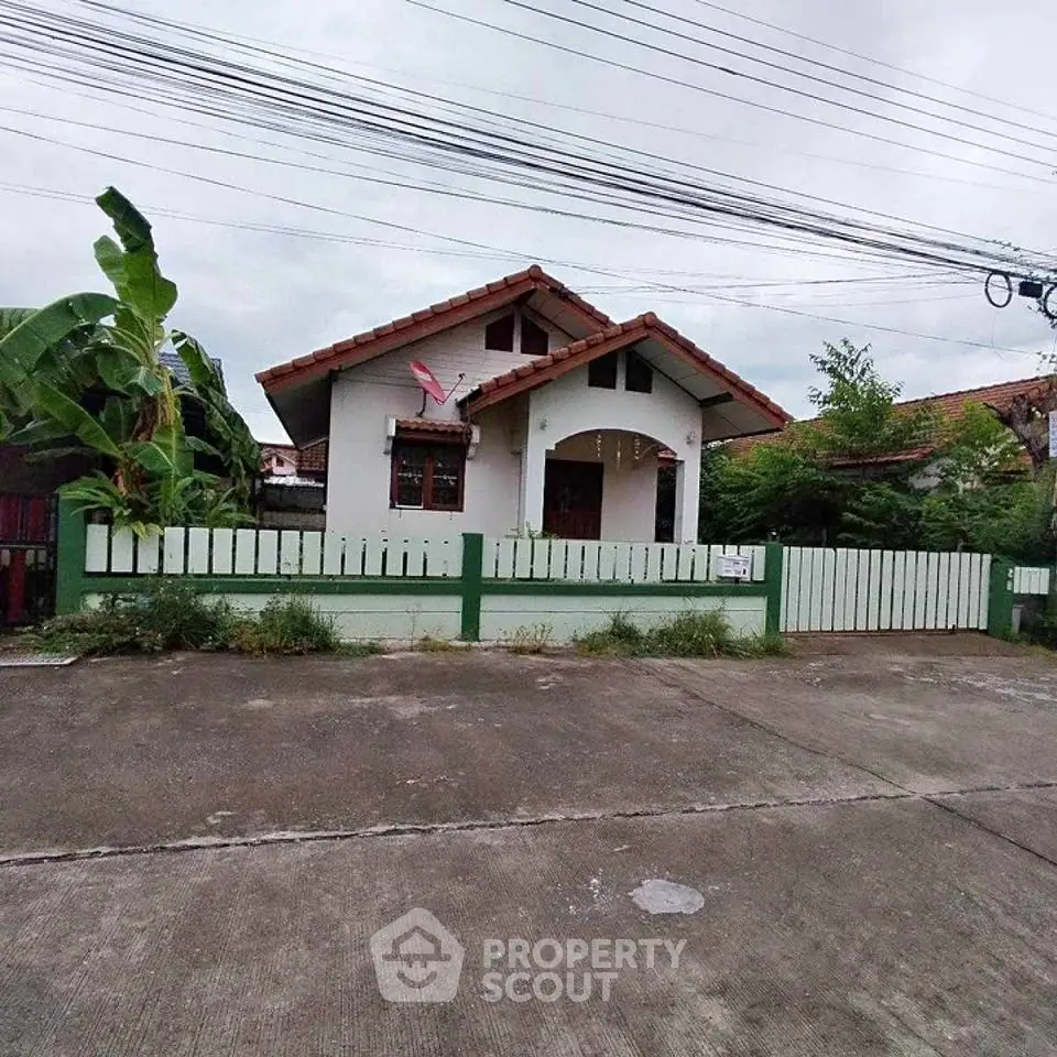 Charming single-story house with tiled roof and fenced yard in a quiet neighborhood.