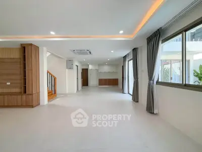 Spacious modern living room with large windows and elegant lighting