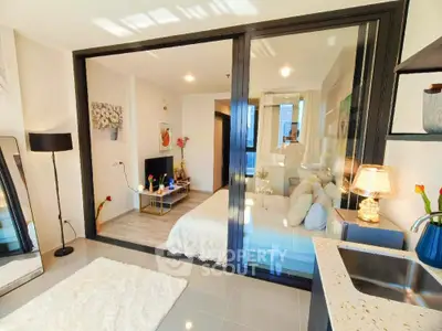 Modern studio apartment with glass partition, cozy living area, and stylish decor