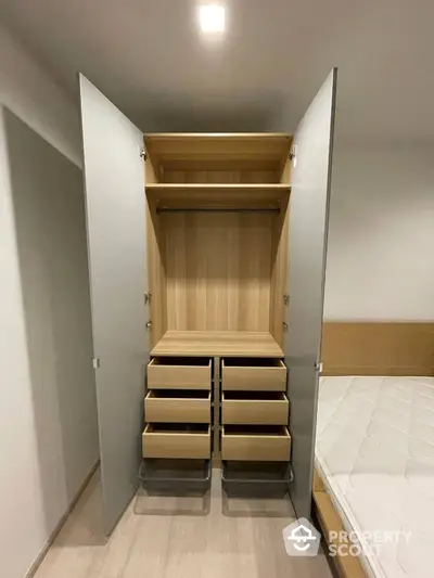 Modern bedroom with open wardrobe showcasing ample storage space and sleek design.