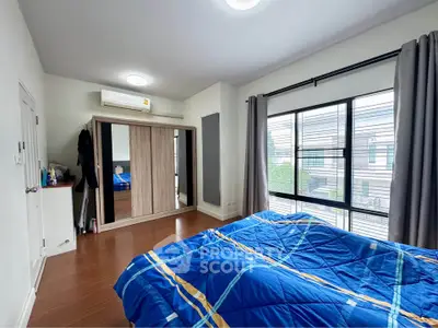 Spacious bedroom with large window and modern decor