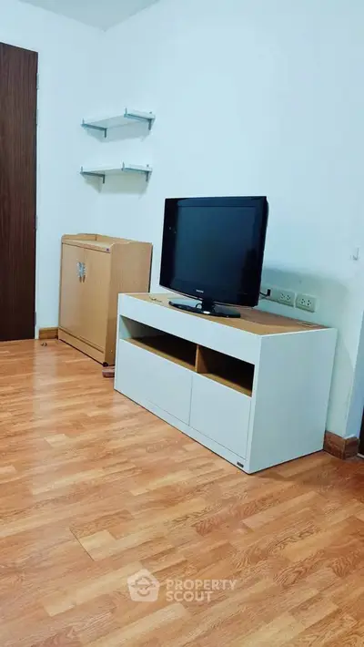 Modern living room with wooden flooring and sleek TV stand, perfect for cozy entertainment.