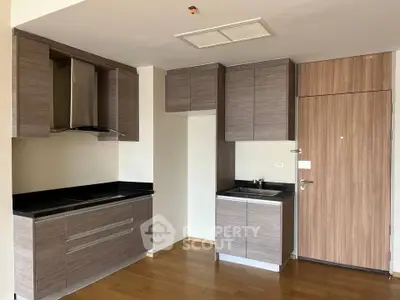 Modern kitchen with sleek cabinetry and wood flooring in a contemporary apartment.