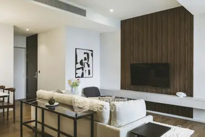 Modern living room with stylish decor and wall-mounted TV, featuring elegant furniture and contemporary design.