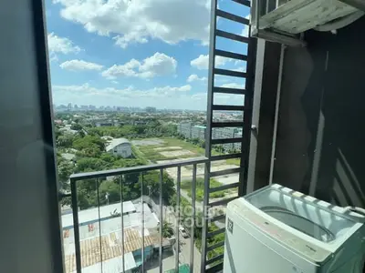 High-rise balcony with stunning cityscape view and washing machine setup.