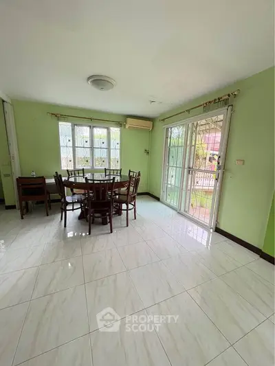 Spacious dining area with natural light and garden view, perfect for family gatherings.