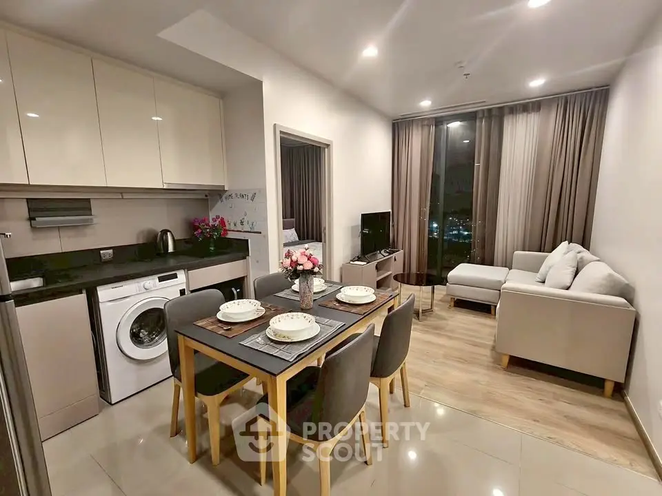 Modern open-plan living room and kitchen with elegant decor and city view.