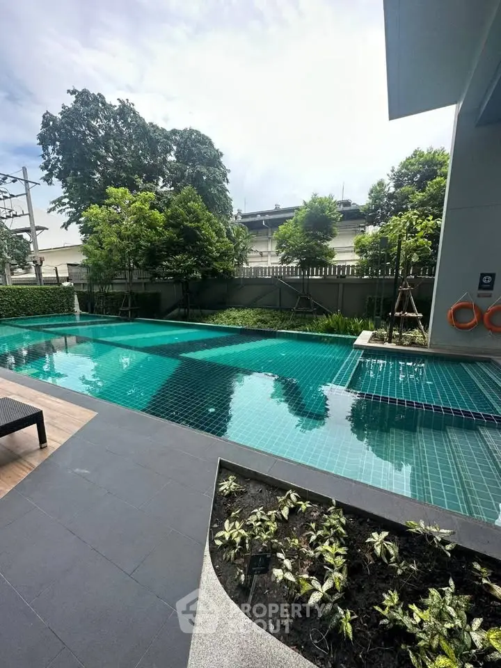 Luxurious outdoor pool area with lush greenery and modern design, perfect for relaxation and leisure.