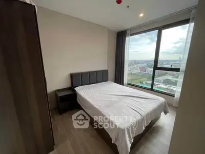 Modern bedroom with large window offering stunning city views, featuring sleek furniture and minimalist design.
