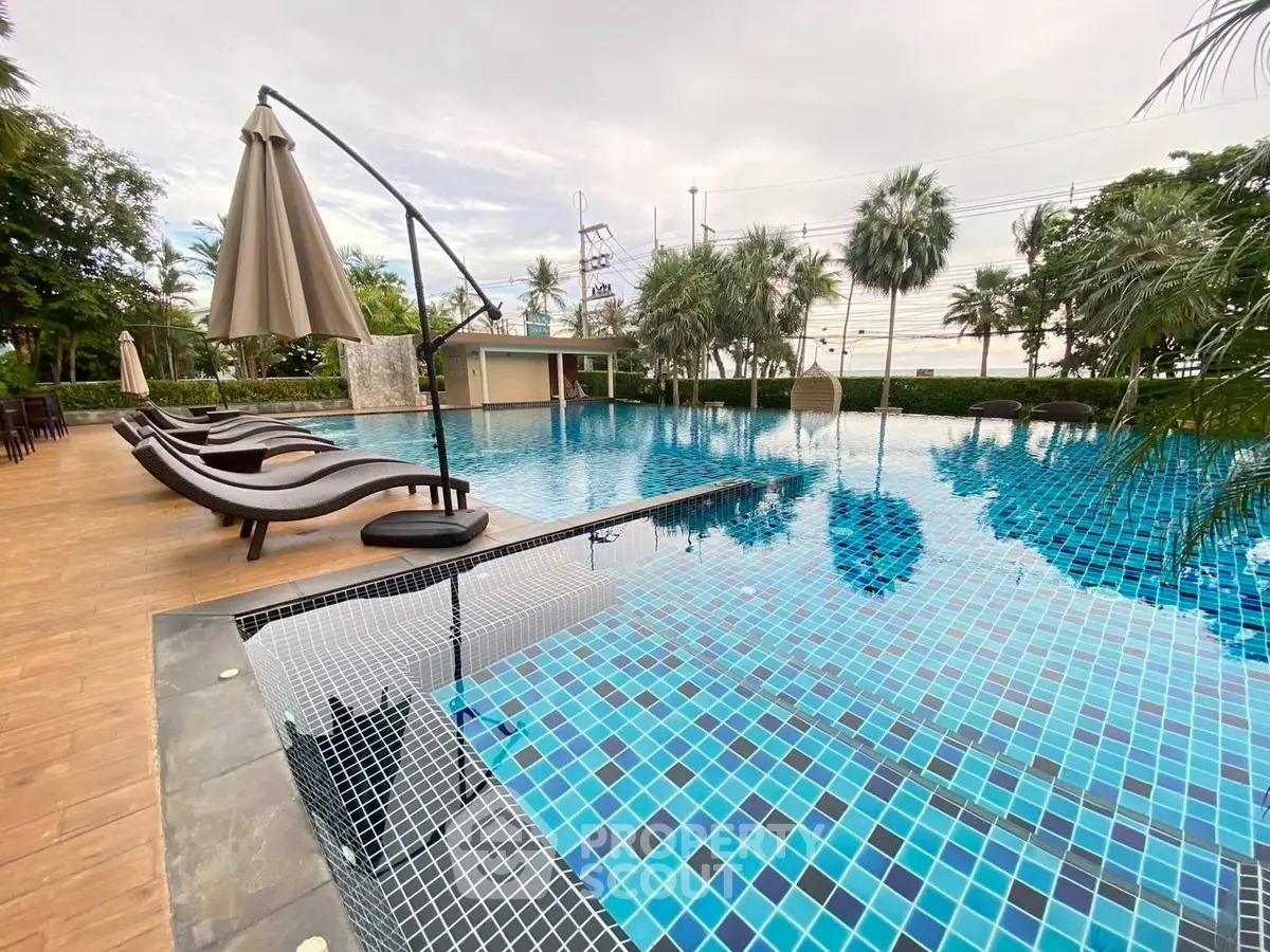 Luxurious outdoor pool area with sun loungers and tropical landscaping, perfect for relaxation and leisure.