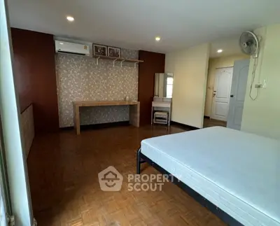 Spacious bedroom with parquet flooring and modern decor
